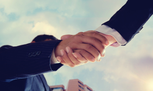 Worm eye view shot of businessmen handshaking.acquisition concept.